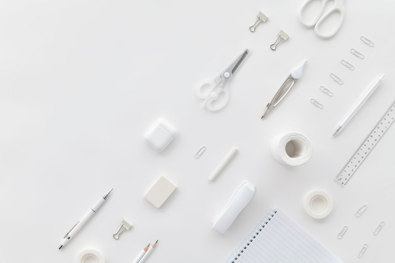 A minimalist top view of white office supplies on a clean desk surface for an organized workspace.